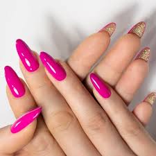 Mão direita acima da mão esquerda. Mostra a mão de uma mulher com unhas compridas, arredondadas na cor rosa.